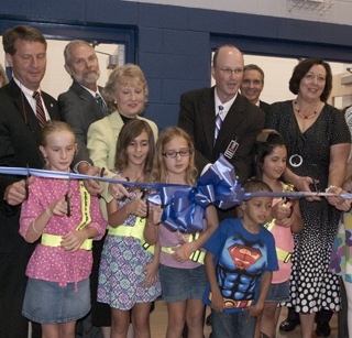 The ribbon cutting at Northshore Elementary School where the leaders cut the ribbon over the shoulders of the students. 