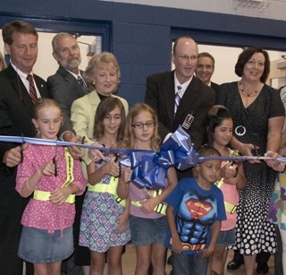 The ribbon cutting at Northshore Elementary School where the leaders cut the ribbon over the shoulders of the students.