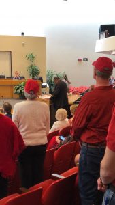 the red shirts standing as Dr. John Butler speaks 