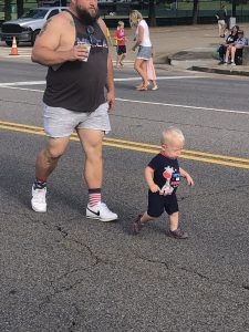 a young toddler checking out the road before the parade began