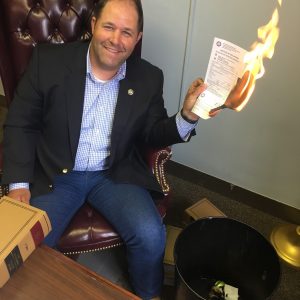 State Rep. Andy Holt burning a red light ticket.