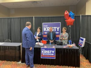 Kristy Kristi, her husband David and campaign volunteer Angie keep their booth as they visit with Davis 